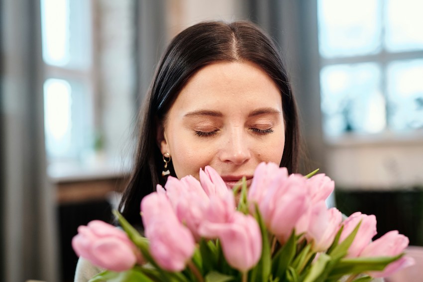 woman enjoying a bouquet of tulips